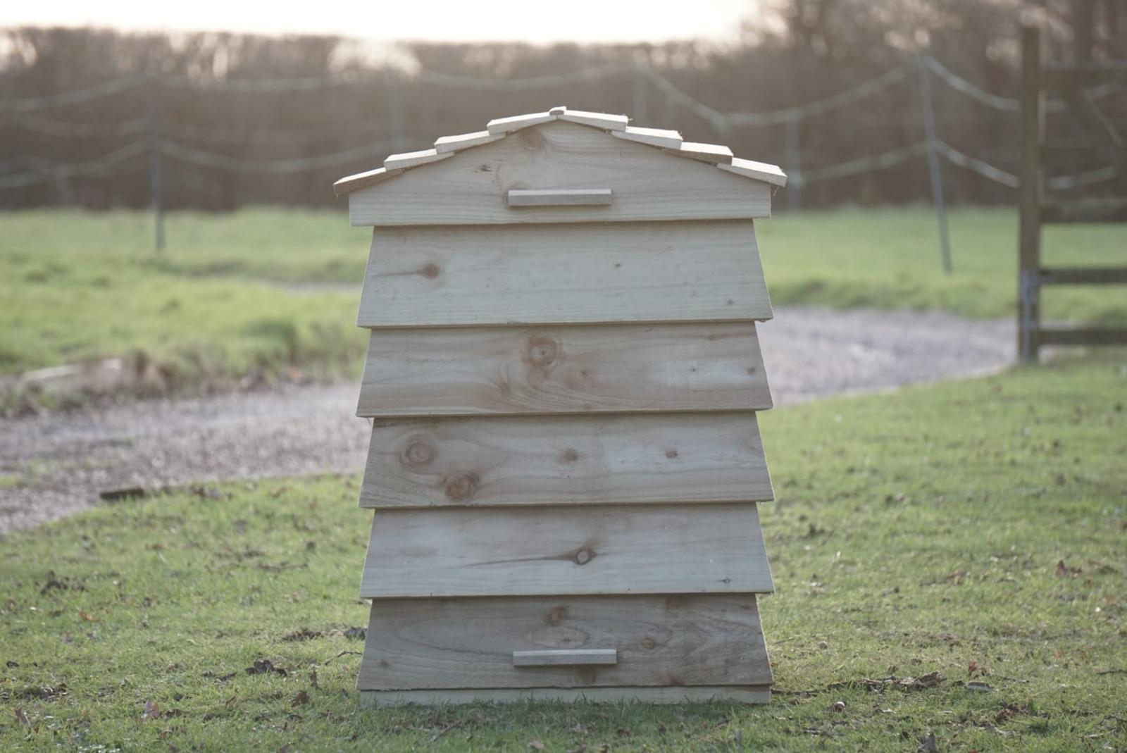 Beehive Composter as a garden focal point alongside raised vegetable beds